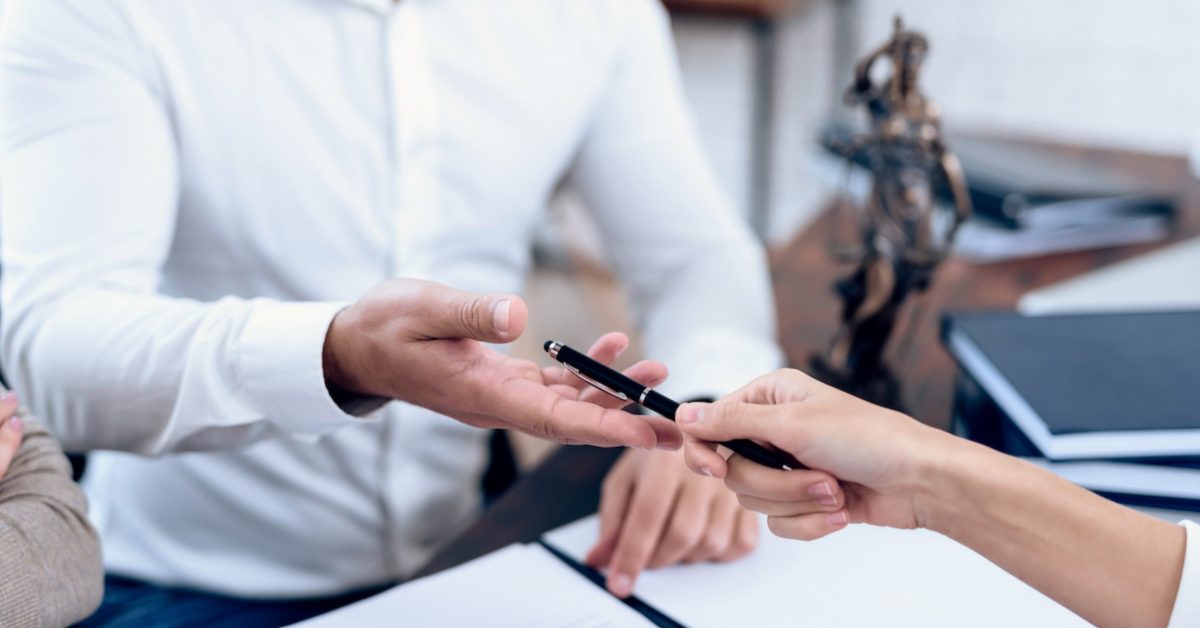 lawyer and client signing documents