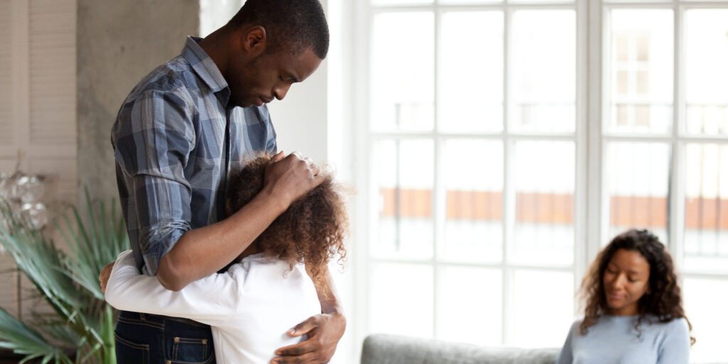 Dad hugging son as parents get divorced.