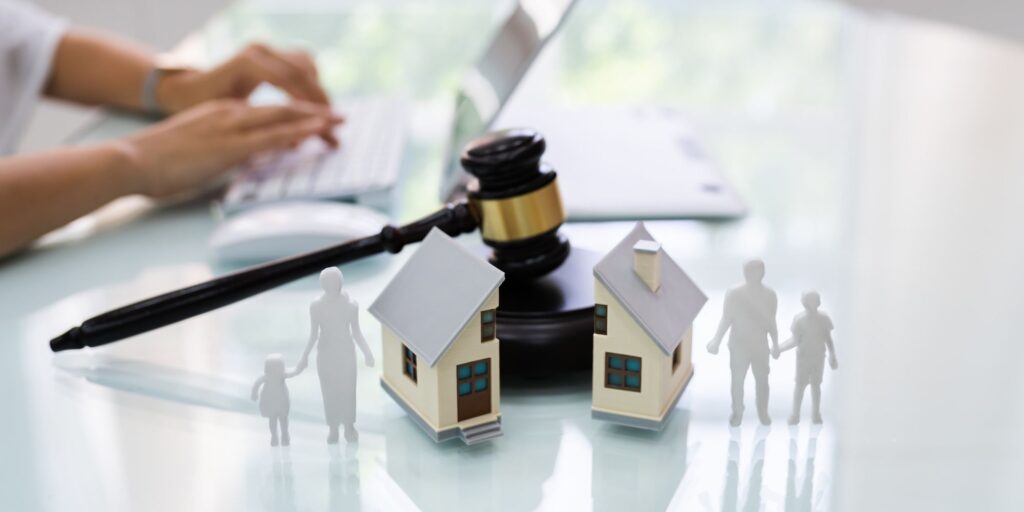 divorced family next to stature house on lawyers desk