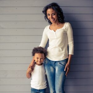 Mother and young son standing together and smiling