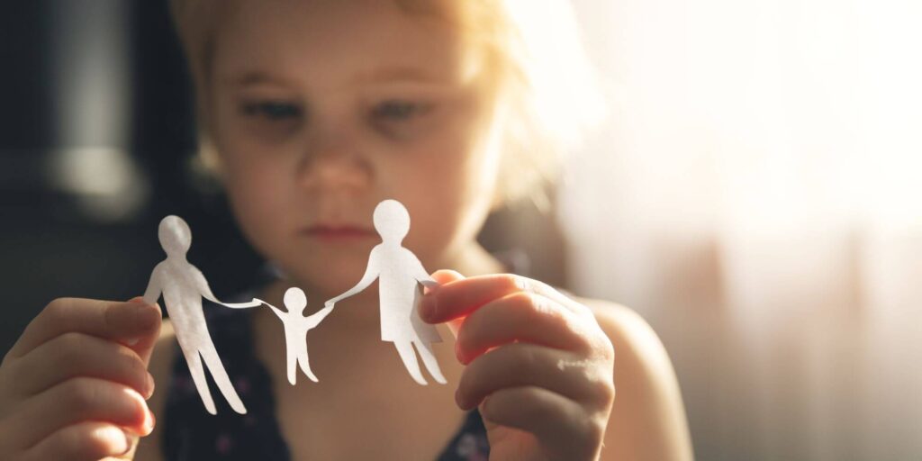 Child with paper cut out of family