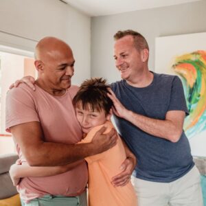 two dads hugging their son