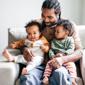 Father holding children with guidance from paternity attorney in New Jersey