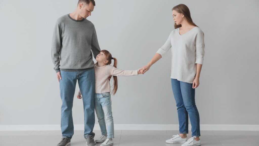 Mother holding daughters hand while dropping her off