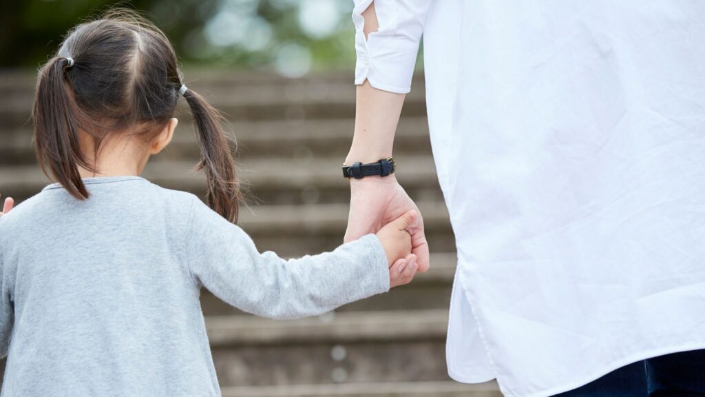 parent holding a child's hand