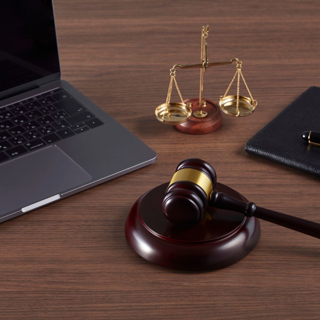 scales of justice, judges gavel, and a laptop