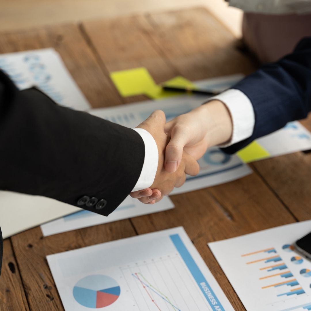 hands shaking above financial documents
